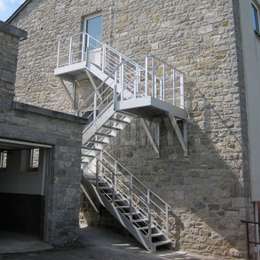 Industrial staircase suspended on the facade of a 2 storey building.