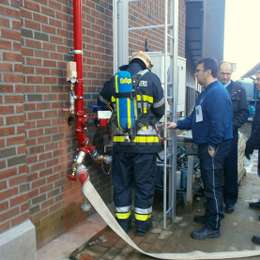 Firefighter getting ready to climb a JOMY retractable ladder during an intervention exercise.