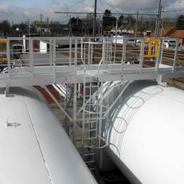 Ladder used to access a walking platform on top of two horizontal storage tanks.