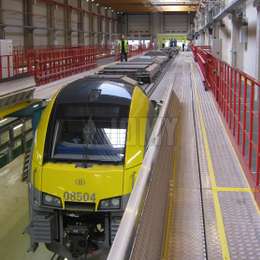 Railway workshop equipped with electrically articulated floors for accessing train roofs.