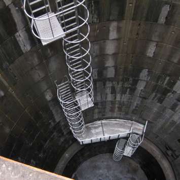 Cage ladder with rest platforms used in an industrial reservoir / well.