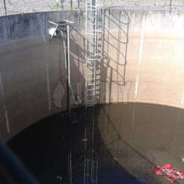 Caged aluminum ladder in sewage tank