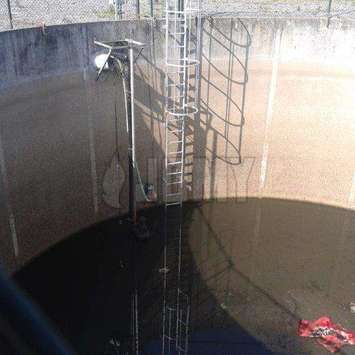 Caged aluminum ladder in sewage tank Caged aluminum ladder in sewage tank