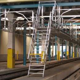 Echelle de meunier utilisée pour accéder à une passerelle dans un atelier de maintenance des trains.