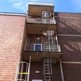 Echelles de secours à crinoline et balcons d'accès en béton.