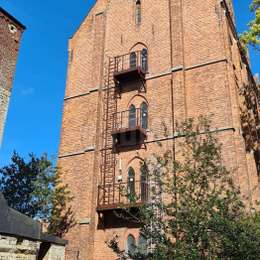 Echelle de secours à crinoline et balcons d'accès pour l'évacuation depuis les fenêtres d'un bâtiment historique en brique.