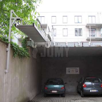 Escalier rétractable avec système de câbles et de poulies Escalier rétractable avec système de câbles et de poulies, utilisé pour l'évacuation incendie d'appartements vers un parking.