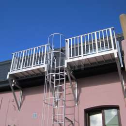 Fire escape cage ladder and access balconies for roof skylights of an attic apartment.