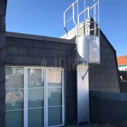 Ladder with a safety cage and an anti-intrusion door used for roof access.