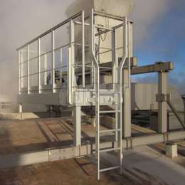 Ladder with widened upper extensions used to climb on an industrial working platform needed for roof machine maintenance.