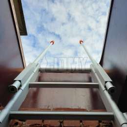 Fixed ladder for accessing a flat roof through the skylight window.