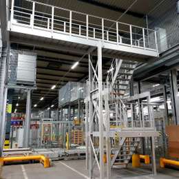 Industriële trap en loopbrug op twee niveaus die in een magazijn worden gebruikt voor toegangsdoeleinden.