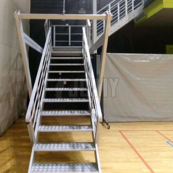 Intrekbare trap met systeem van kabels en katrollen in een sportschool.