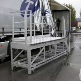 Aluminium mobile platform with stairs and guardrails, used to climb on tuck trailers.