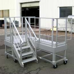 Mobile work platform with stairs and prolonged guardrails.