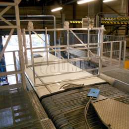 Veiligheidsleuning voor valpreventie bij werkzaamheden aan daken van bussen en touringcars tijdens onderhoudswerkzaamheden in een werkplaats.