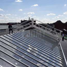 Passerelle de maintenance sur rails et utilisée pour le nettoyage des fenêtres de toit d'une usine.