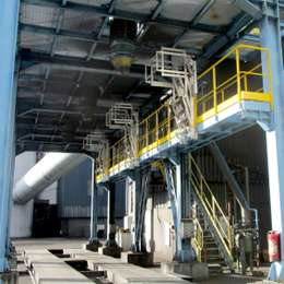 Pivoting aluminium safety cage with stairs, fixed on a platform, and used to access tanker trucks from above.