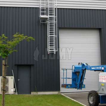 Uitschuifbare ladder met dubbel kooi en rustplatform buiten een magazijn.