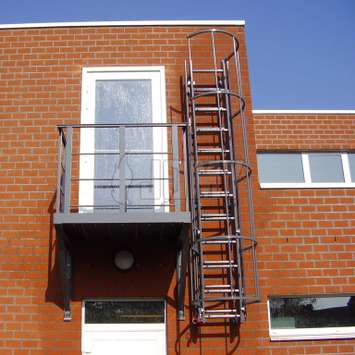 Uitschuifbare ladder in RAL kleur met toegangbalkon voor brandevacuatie.