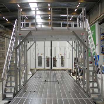 Industriële werkbordes met toegangstrappen en toegangsluik op een motor productielijn.